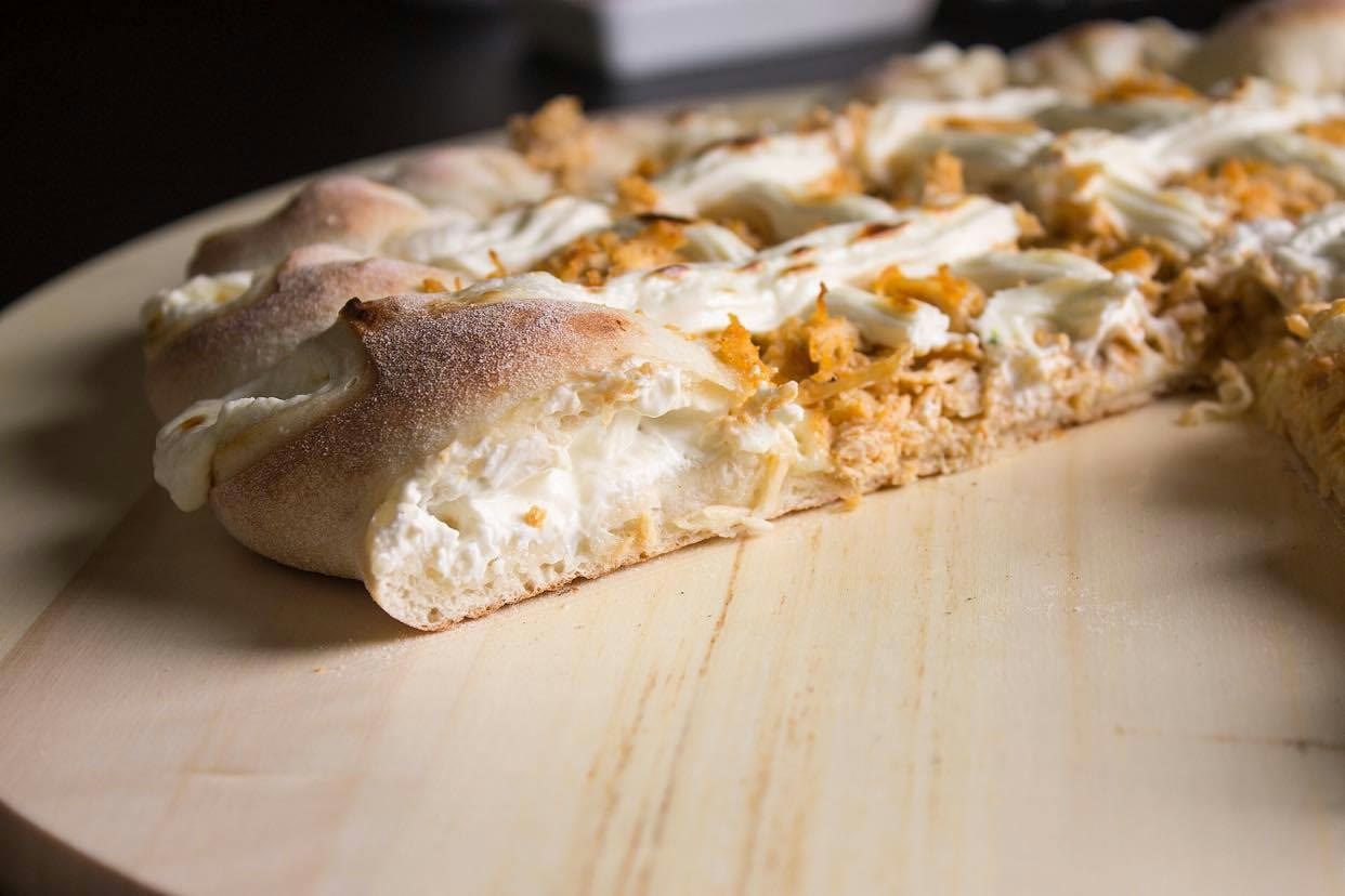 Rebordo recheado com queijo derretido, em pizza da Vila Madalena